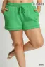 Green shorts worn by a person on a plain background