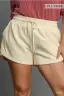 Beige shorts worn by a person on a plain background