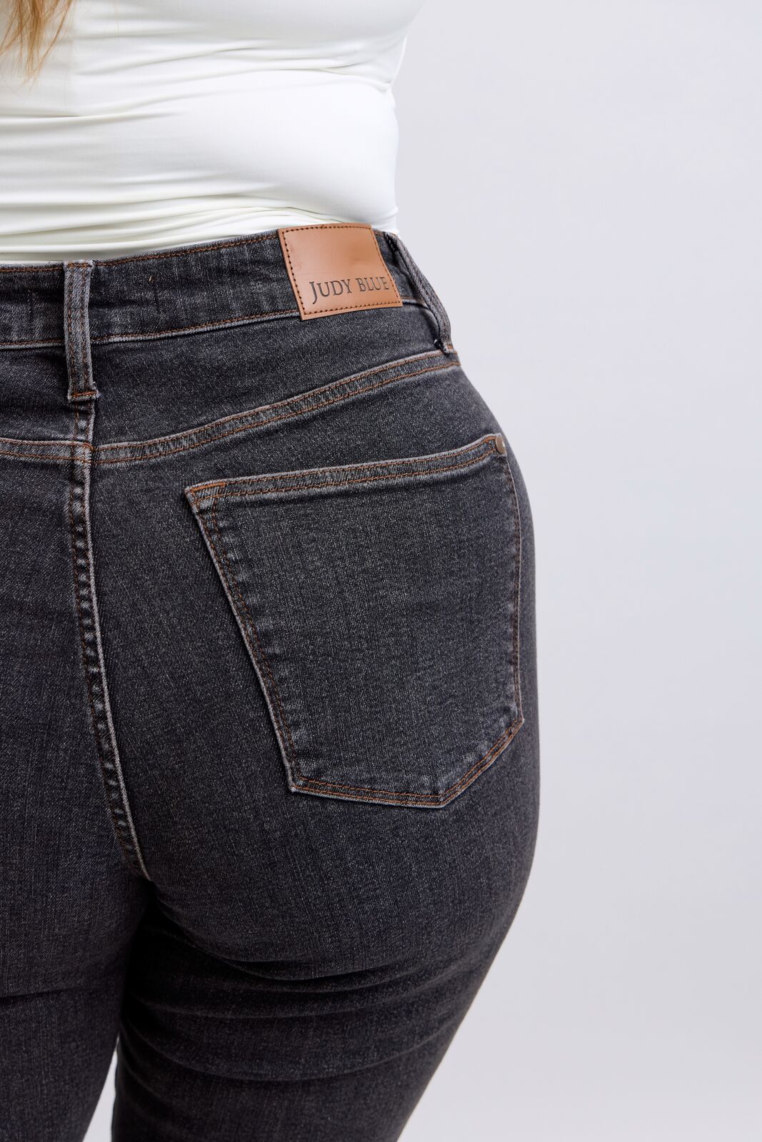 Dark blue jeans with a brand label on a white background