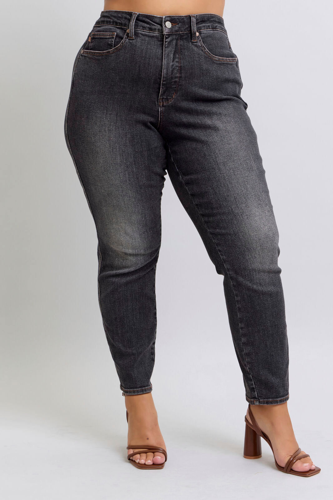Black jeans worn by a person on a white background