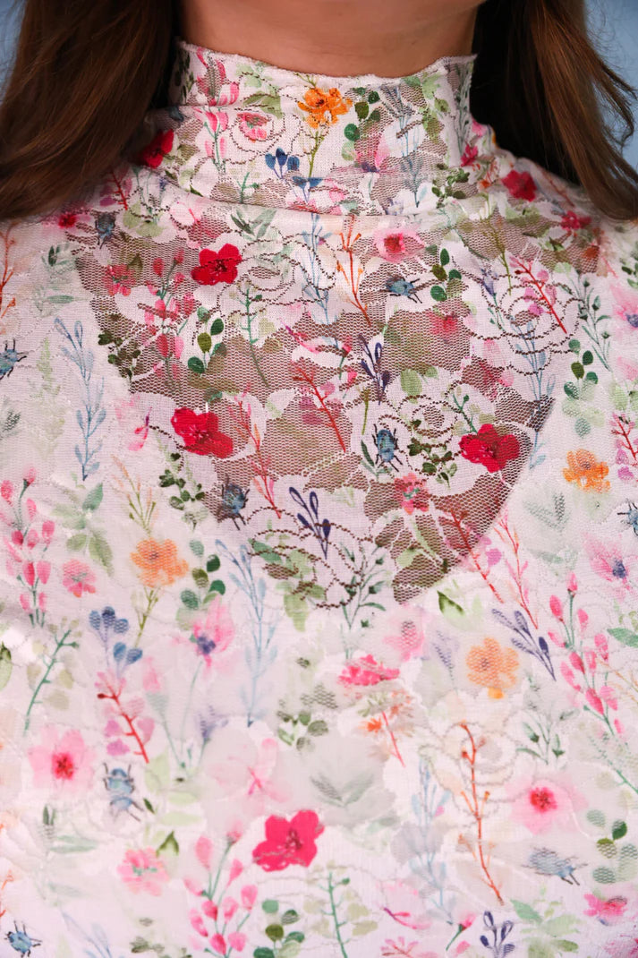 Close-up of a floral lace garment with colorful flowers on a white background