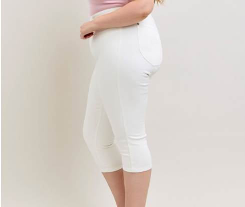 Person wearing white high-waisted shorts on a plain background