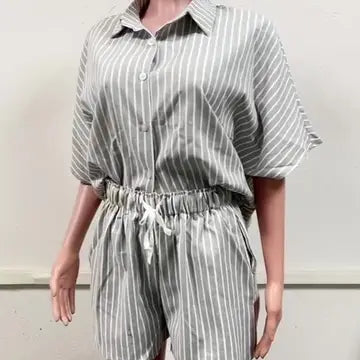 Person wearing a gray and white striped jumpsuit against a plain background
