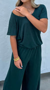 Person wearing a green jumpsuit against a light gray background
