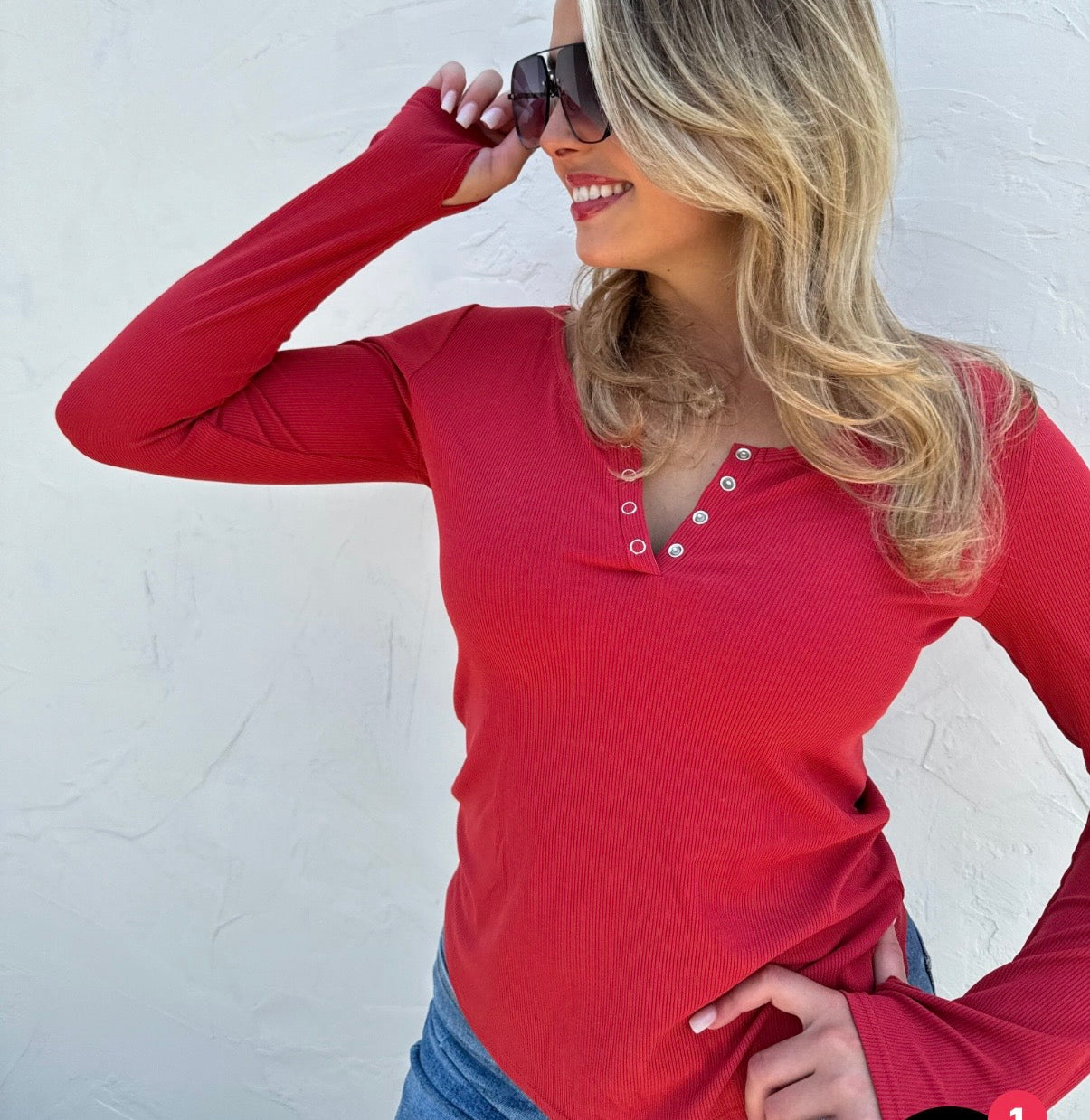 Woman wearing a red long-sleeve shirt against a white background