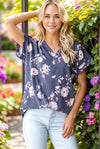 Woman wearing a floral blouse with a garden background