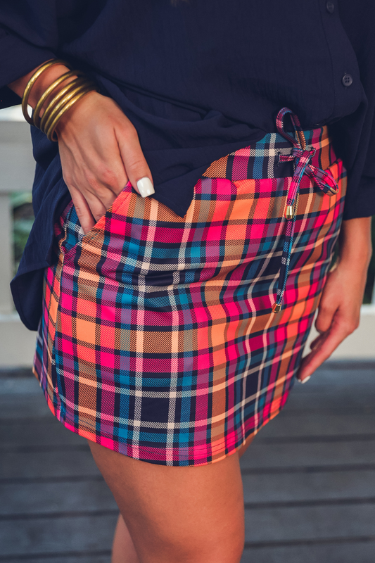 Multicolored plaid skirt worn by a person with a blurred background
