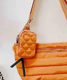 Orange quilted handbag with a matching pouch on a light gray background