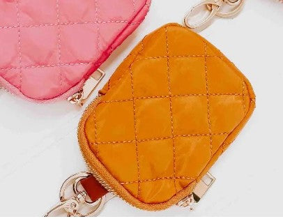 Two quilted coin purses, one pink and one orange, on a light background.