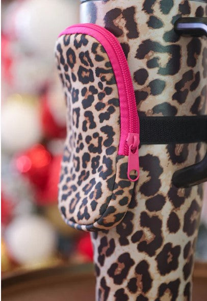 Leopard print water bottle holder with pink zipper on a blurred background
