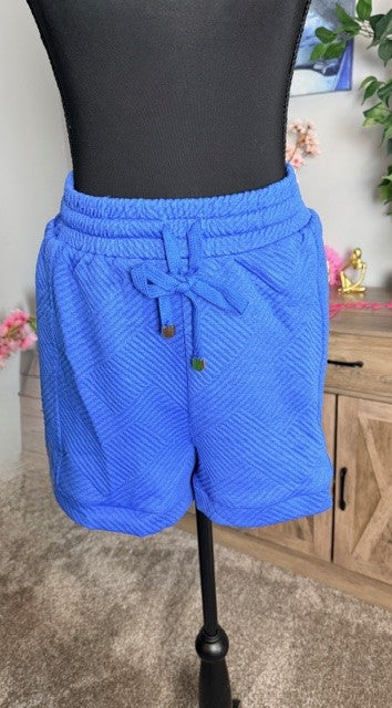 Blue shorts on a mannequin against a neutral background