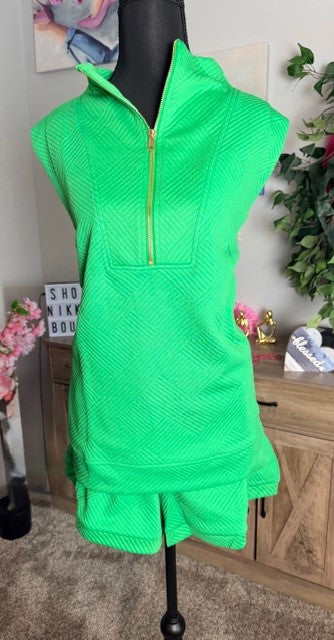 Neon green sleeveless dress on a mannequin with a blurred indoor background