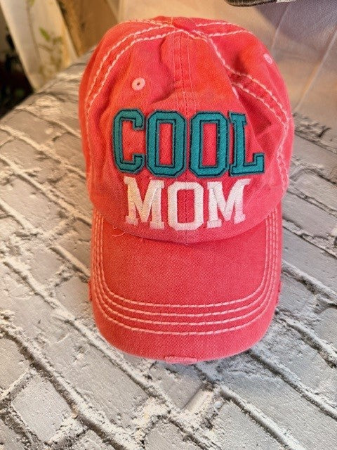Red cap with 'COOL MOM' text on a textured surface