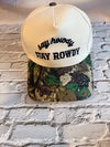 Two baseball caps with 'stay rowdy' text on a brick wall background
