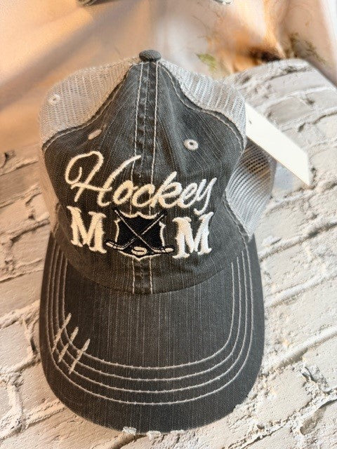 Black cap with 'Hockey Mom' text on a stone surface