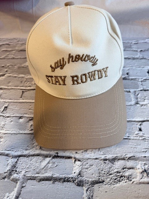 Beige cap with 'Stay Rowdy' text on a brick wall background