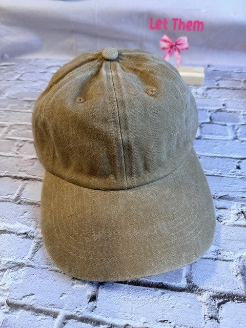 Beige baseball cap on a textured surface with 'Let Them' text and pink bow in the background.