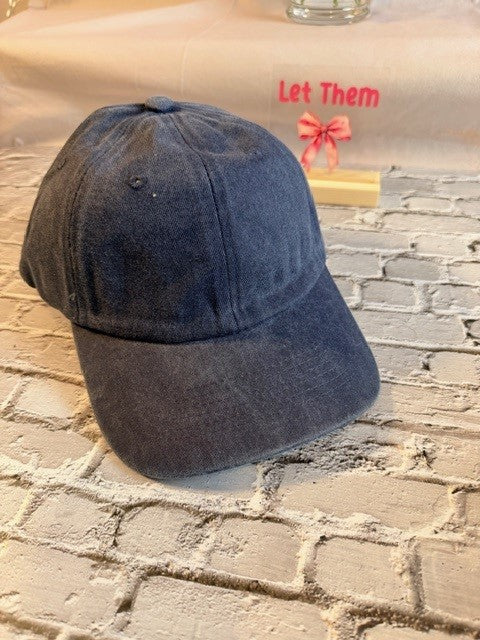Blue denim cap on a textured surface with a blurred background