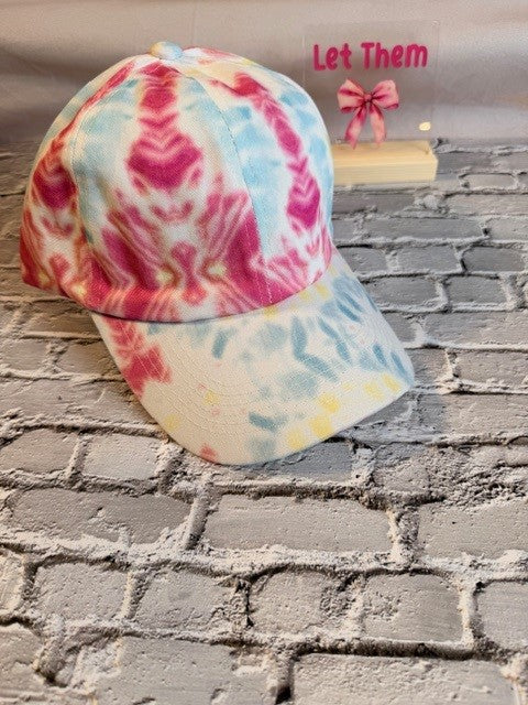Colorful tie-dye cap on a textured surface with text overlay