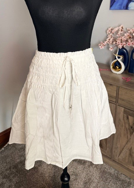 White skirt on a mannequin against a neutral background